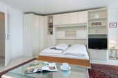 Wohn-/Schlafbereich mit Doppelschrankbett und TV