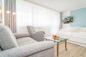 Wohn-/Schlafraum mit Sofa, Sessel und Doppelbett
