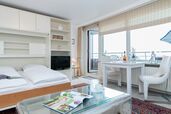 Wohn-/Schlafbereich mit Doppelschrankbett, TV und Zutritt zur Westloggia mit Meerblick