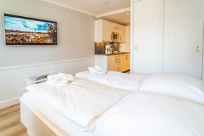 Wohn-/Schlafbereich mit Doppelbett, TV und offener Küchenzeile